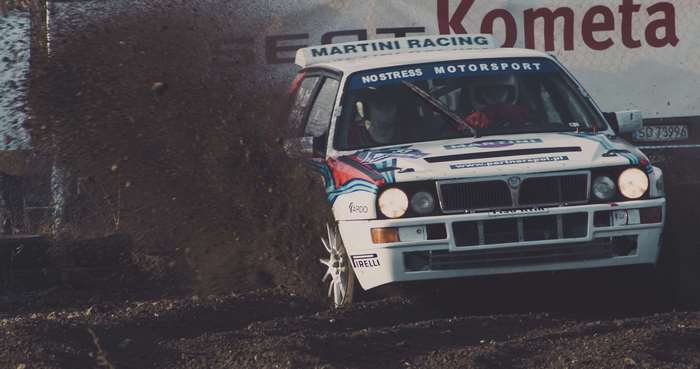 Lancia Delta Martini Racing rally car kicking up dirt
