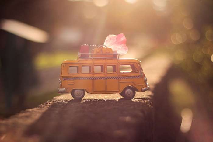 Yellow toy van with luggage on a sunny day