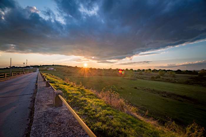 Sunset over a rural landscape with a road