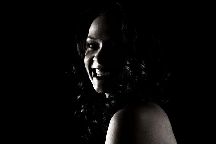 Woman with curly hair smiling in black and white