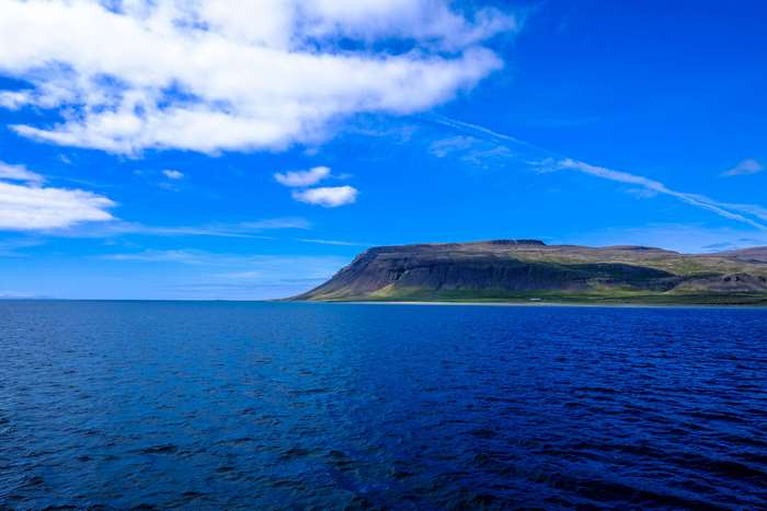 Ocean and Mountain Landscape with Blue Sky and Clouds