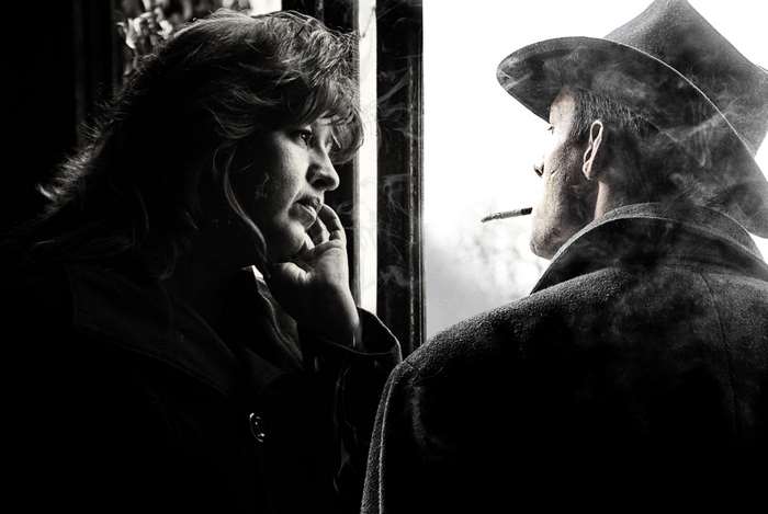 Man and woman by a window, smoking