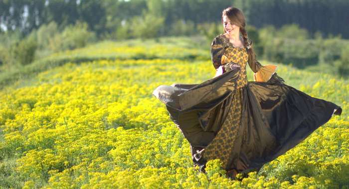 Woman in a vintage dress in a field of yellow flowers 4K
