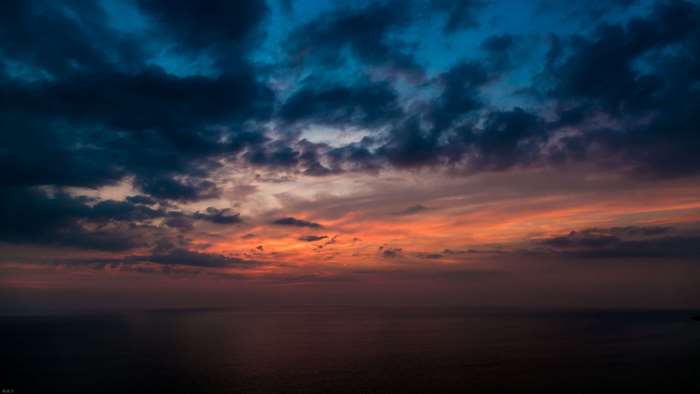 Sunset over the ocean with dramatic clouds