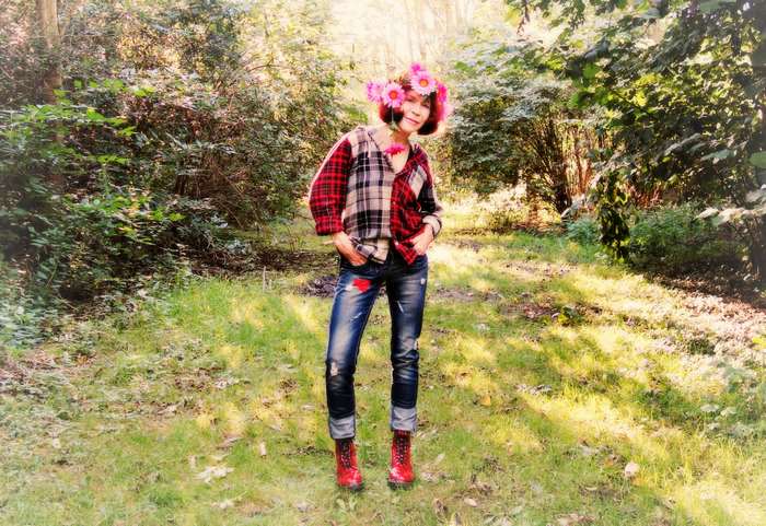 Woman with flower garland wearing ripped jeans and plaid shirt