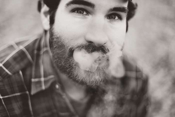 Man with beard smoking, close up portrait