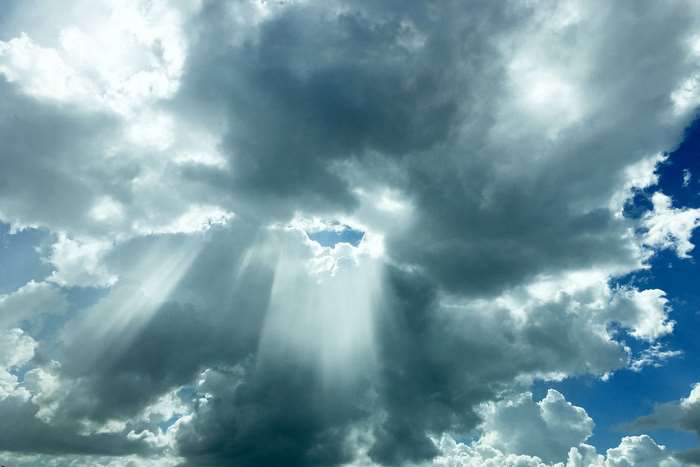 Sunbeams breaking through dark clouds in the sky