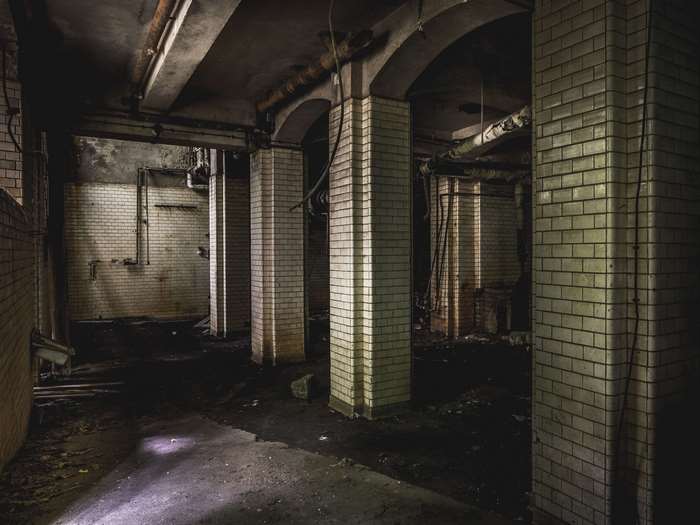 Abandoned building interior with arches and tiled columns