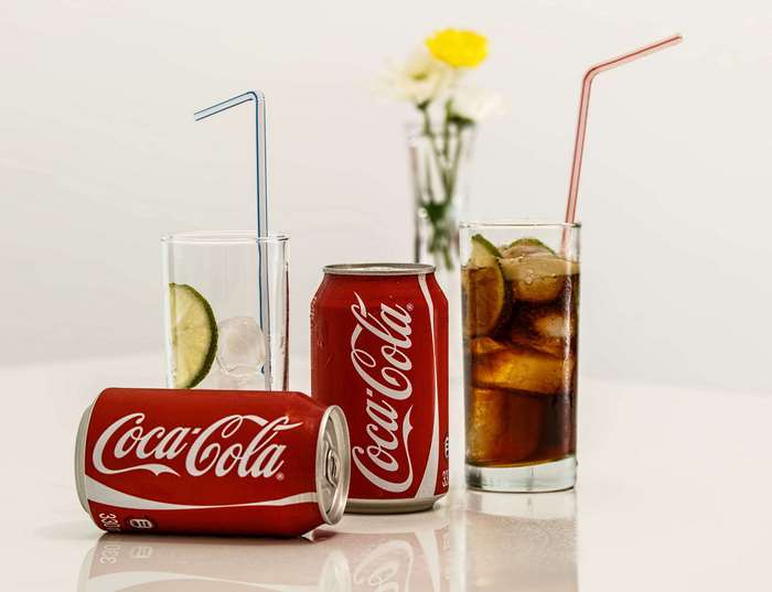 Coca-Cola cans and glasses with ice and lime