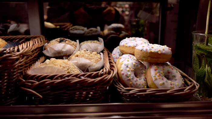 Donuts and muffins in baskets with a glass of mint