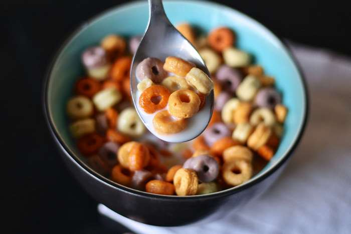 Bowl of colorful cereal with milk on a spoon