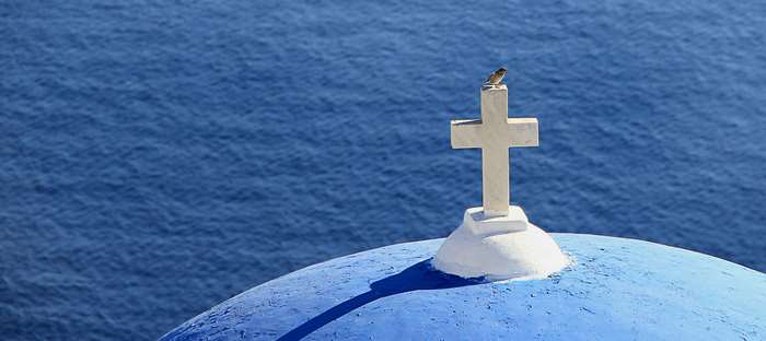 Christian cross on blue dome with bird, Santorini 4K