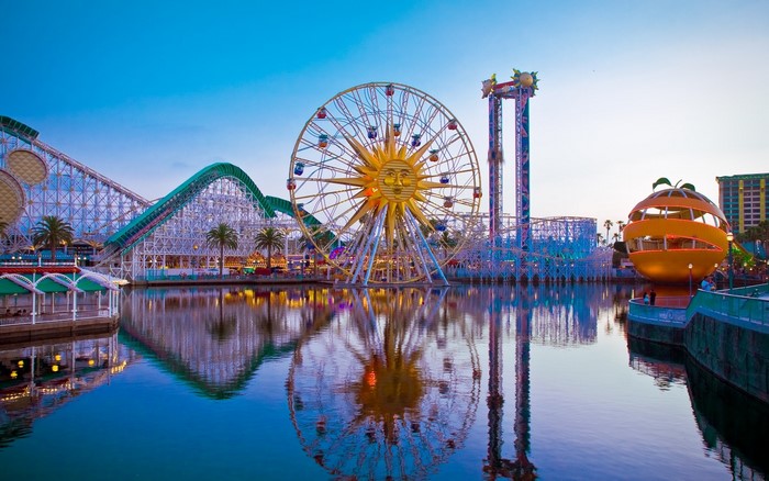 Amusement park with Ferris wheel and roller coaster at dusk