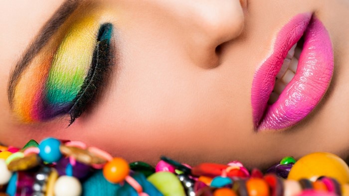 Woman with colorful eye makeup and pink lipstick