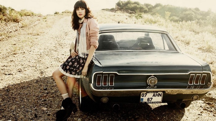 Girl leaning on a vintage Ford Mustang