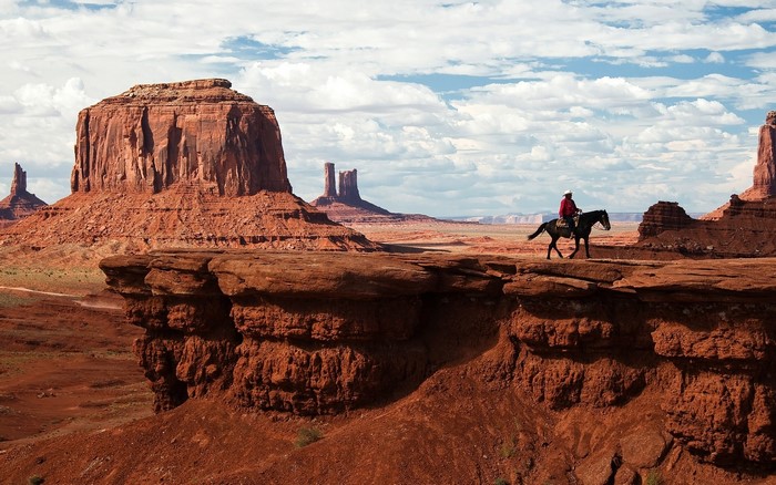 Cowboy on horseback in Monument Valley desert