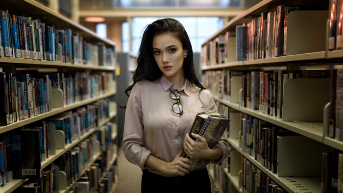 Young Woman Reading Books in Quiet Library