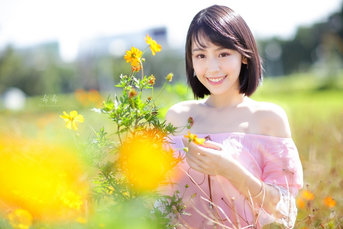 Smiling Woman with Yellow Flowers in Sunlight