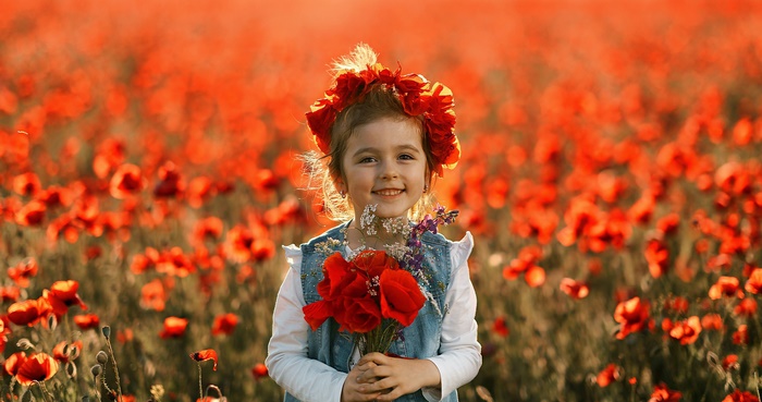 Girl with a wreath and poppies in a field