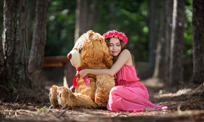 Girl Embracing Teddy Bear in Forest Setting