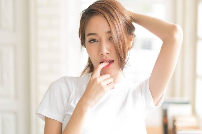 Asian woman with hand on mouth