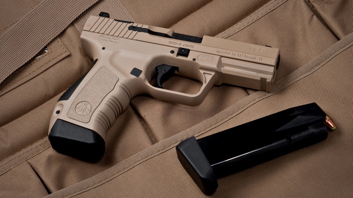 Tan pistol with magazine on tan fabric