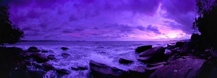 Purple sunset over rocky ocean coast