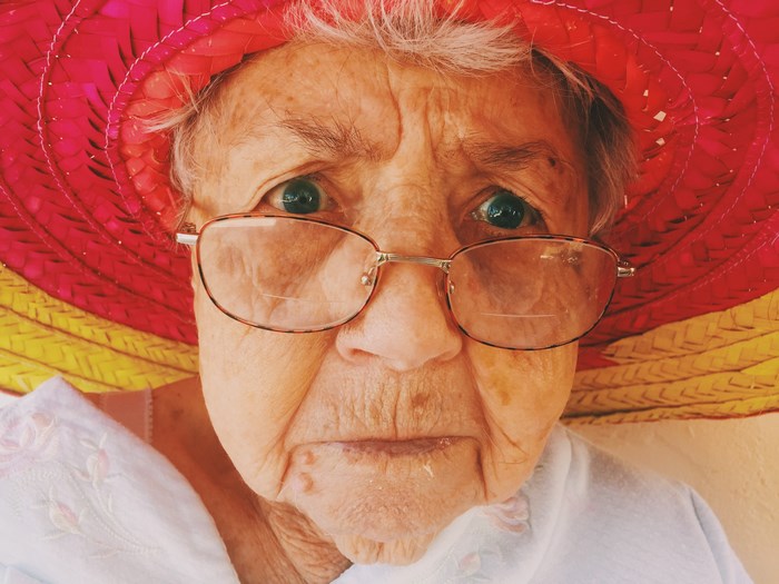Elderly woman wearing a colorful hat and glasses