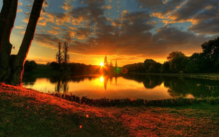 Sunset over a lake with trees and clouds