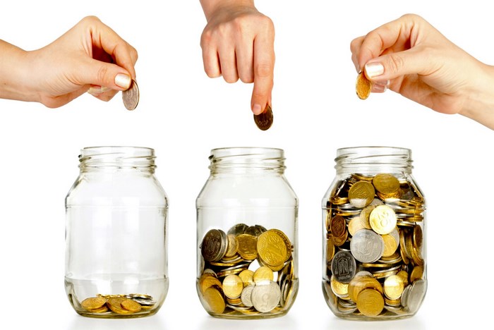 Hands dropping coins into glass jars