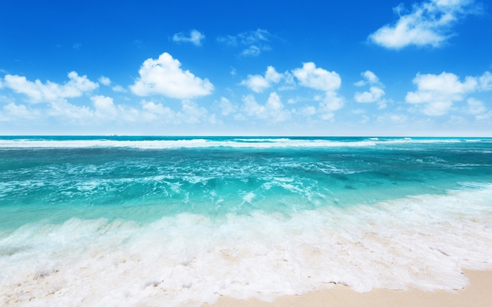 Ocean waves and blue sky with clouds