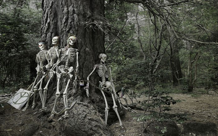 Skeletons with peace sign in a forest