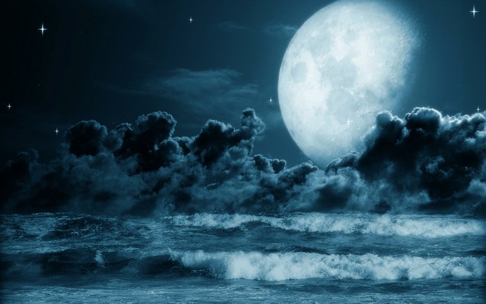 Full moon over ocean waves at night