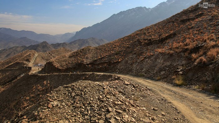 Mountain road with rocky slopes and distant peaks