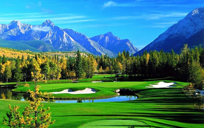 Golf course with mountains and autumn trees