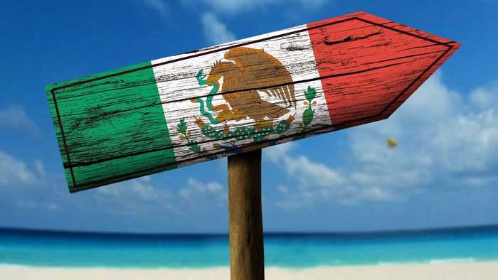 Mexico flag signpost on a beach