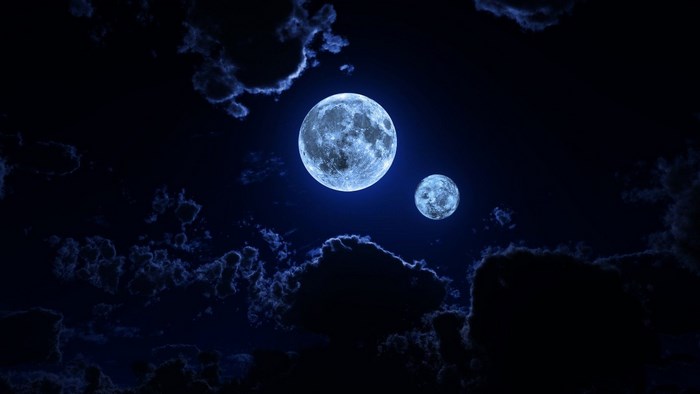 Two moons in a dark, cloudy night sky