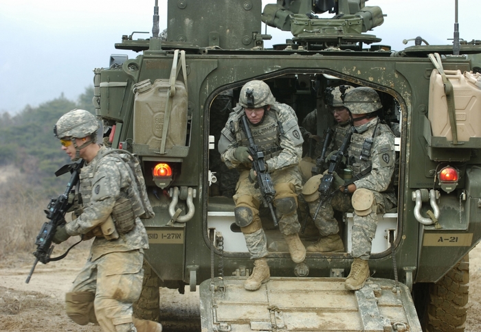 US Army soldiers disembarking from a Stryker vehicle