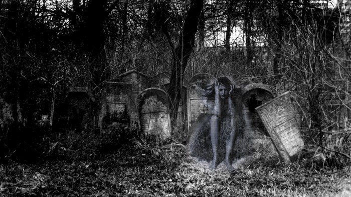 Ghostly figure in a dark cemetery