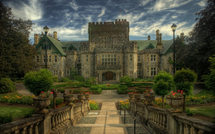 Castle with manicured gardens and cloudy sky