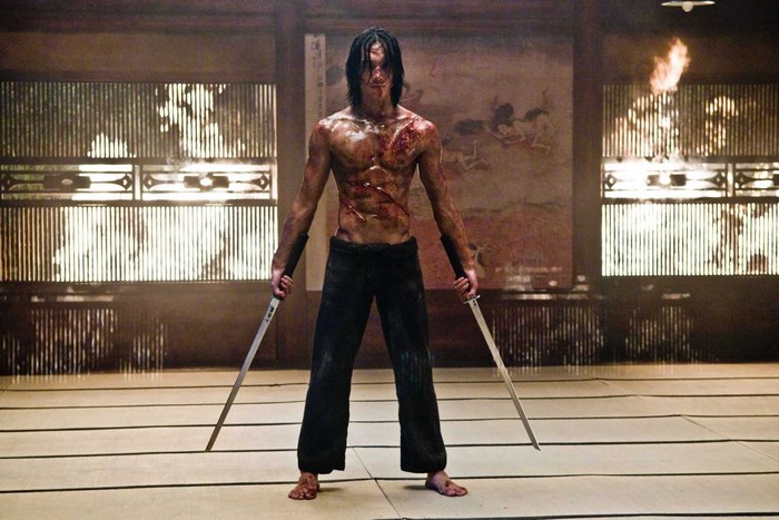 Man with swords in traditional Japanese room
