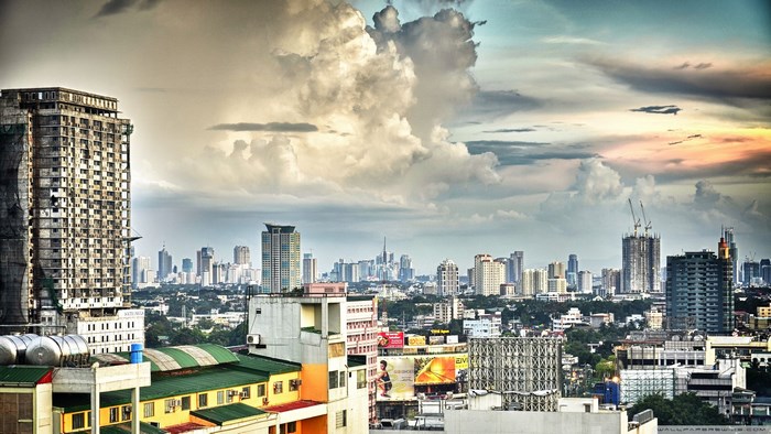 Cityscape with unfinished skyscraper and cloudy sky