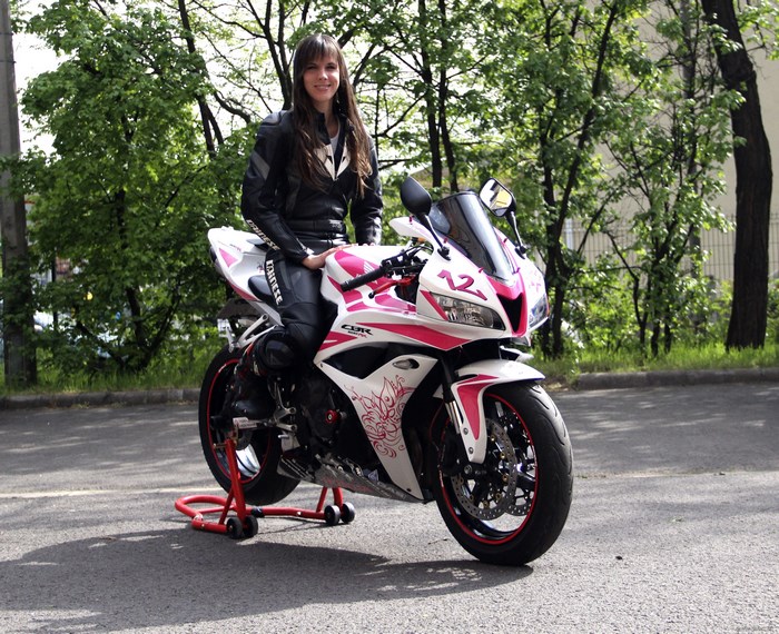 Woman in leather suit on a pink and white Honda CBR600RR