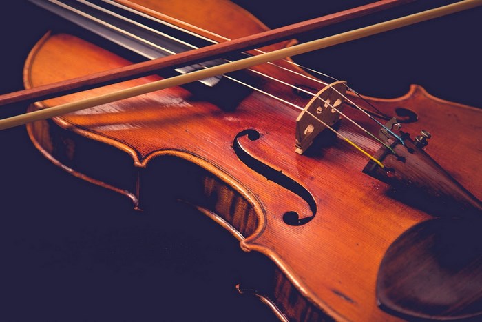 Violin with bow on dark background