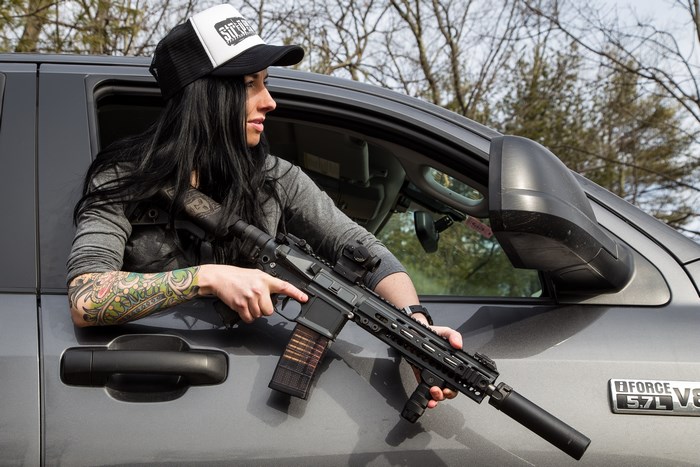 Woman with rifle in truck