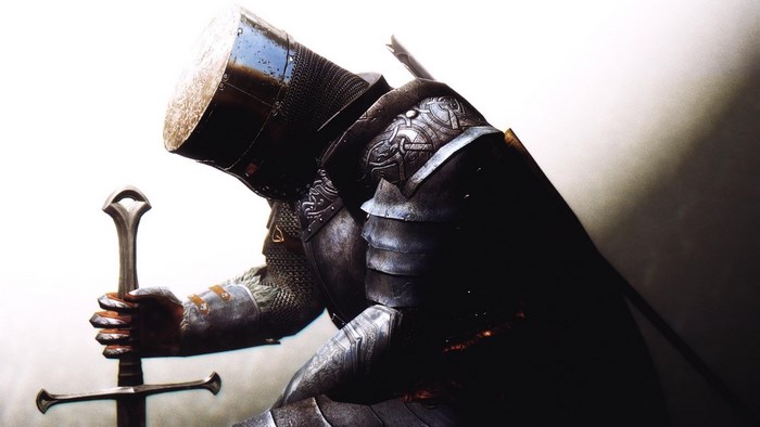 Knight in armor kneeling with sword