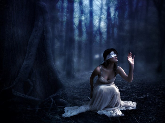 Blindfolded woman in a dark forest