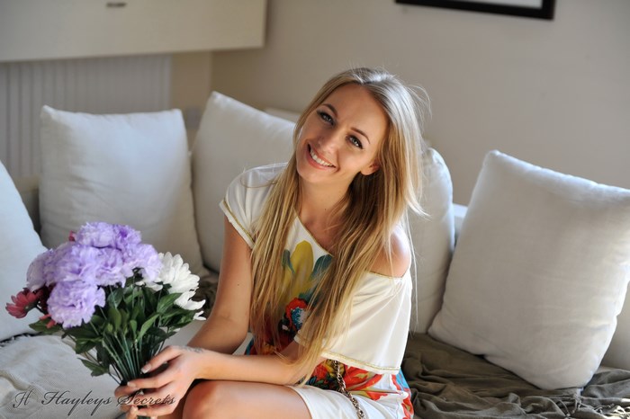 Smiling Woman Holding Purple and White Flowers