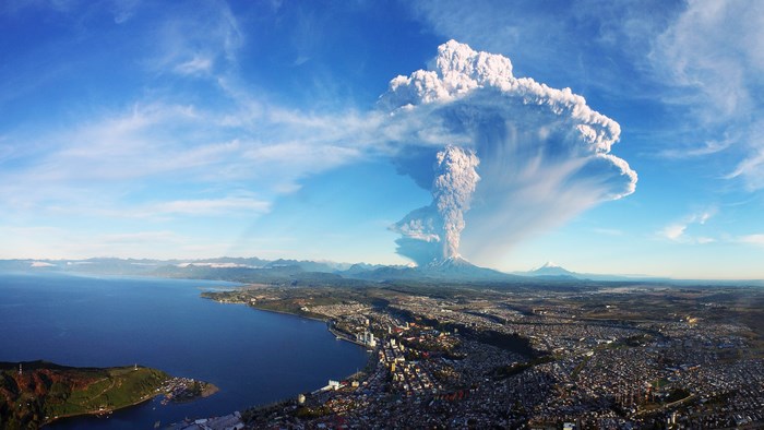 Volcanic eruption over a city and bay