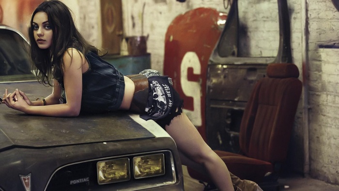 Mila Kunis posing on a Pontiac car